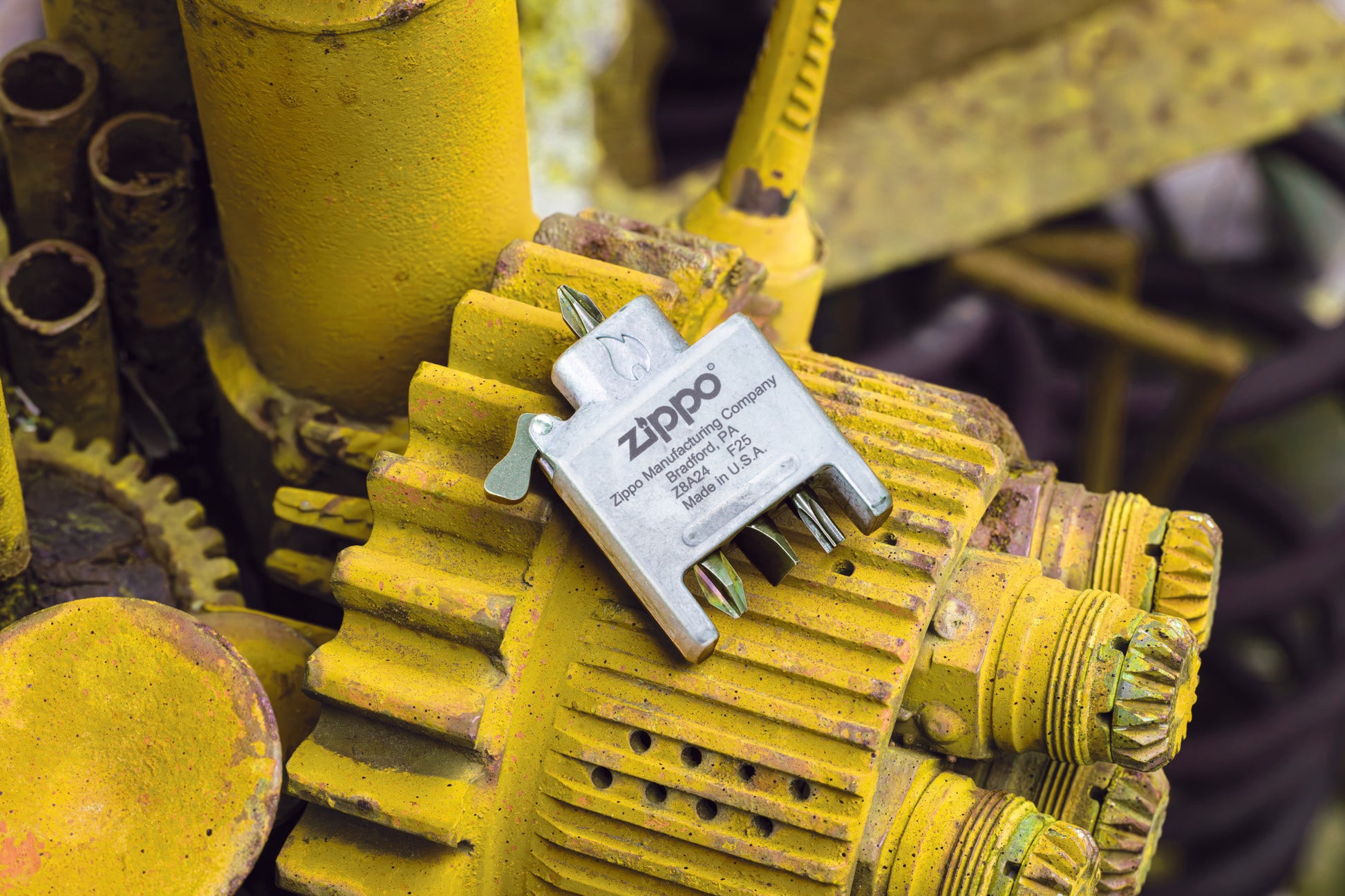 Lifestyle image of Bit Safe Screwdriver Lighter insert laying on a yellow engine.