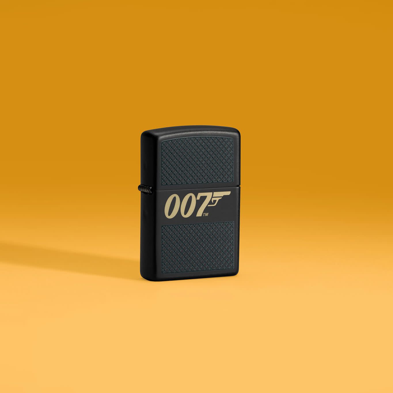 Lifestyle image of Zippo James Bond 007â„¢ Design Black Matte Windproof Lighter on a pale orange background.