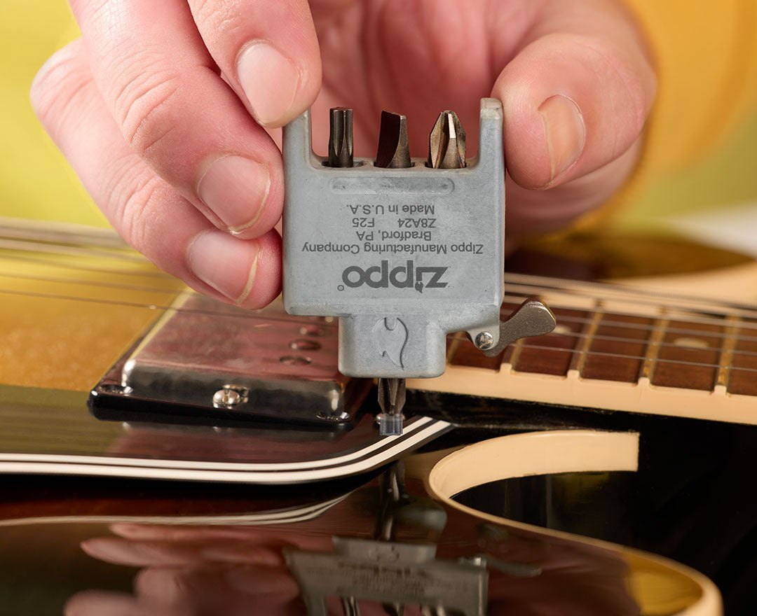 Person using a Bit Safe Insert tool on an acoustic guitar
