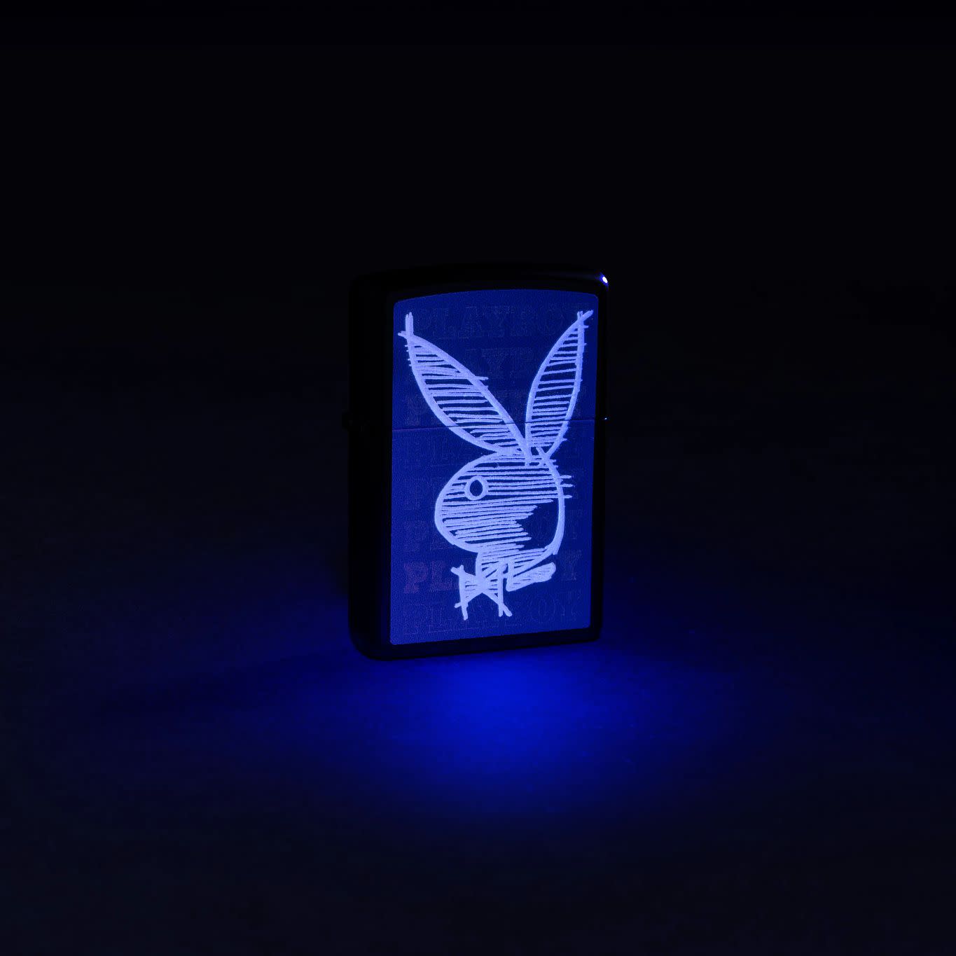 Lifestyle image of Zippo Black Light Rabbit Design Black Matte Windproof Lighter glowing under a black light.