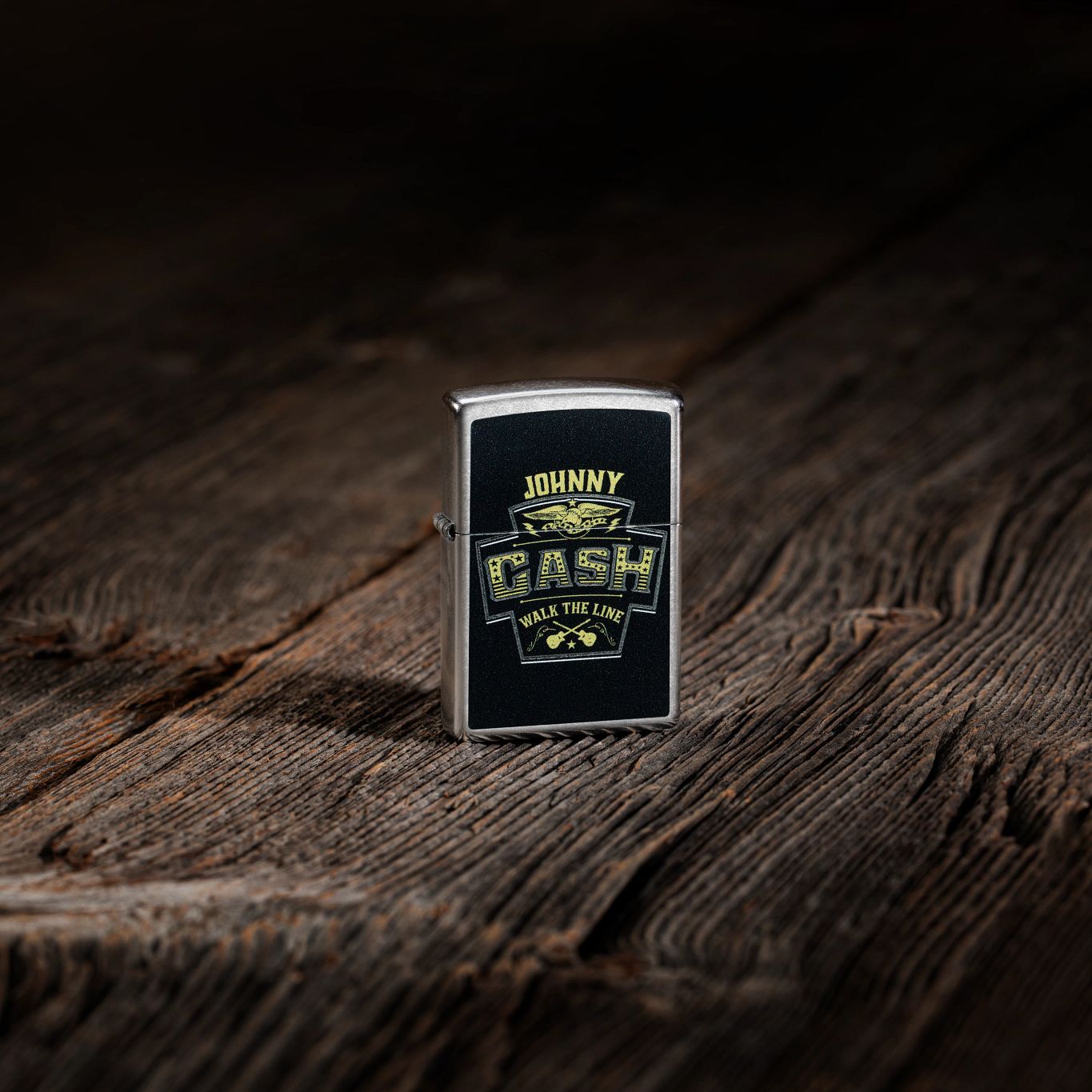Lifestyle image of Zippo Johnny Cash Marquee Design Street Chrome Windproof Lighter standing on a wooden surface.