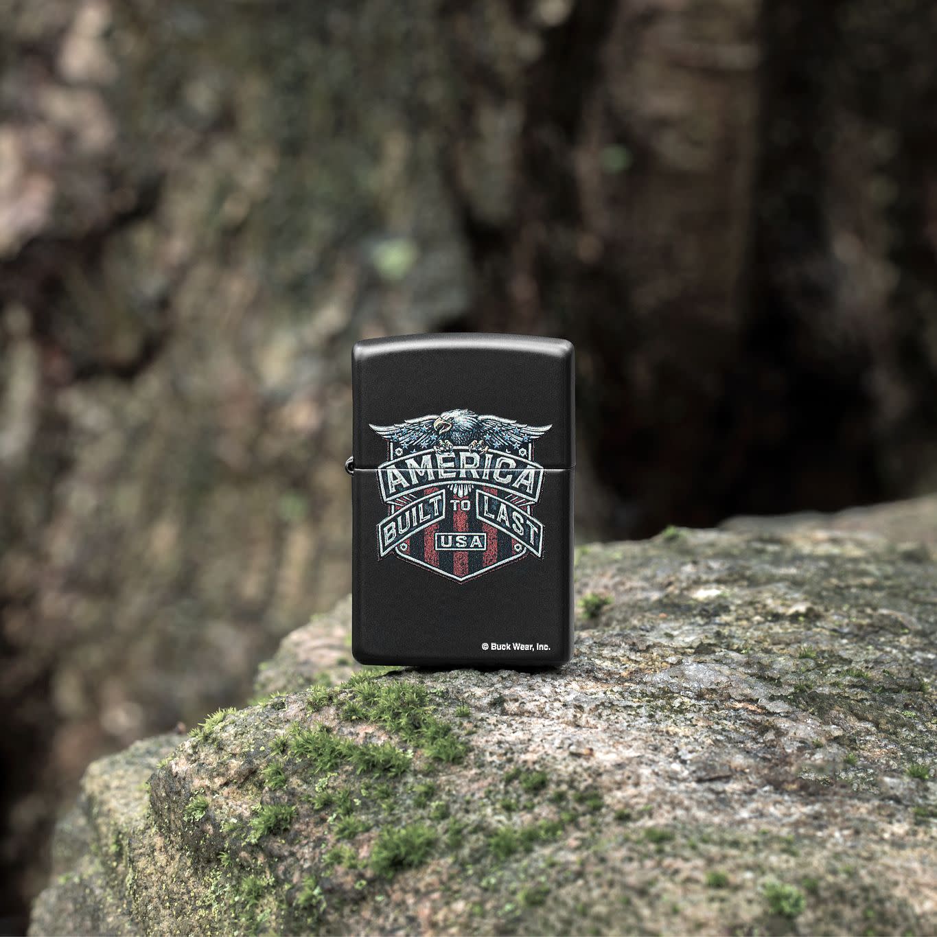 Lifestyle image of Zippo Buck Wear Eagle Design Black Matte Windproof Lighter standing on a mossy rock.