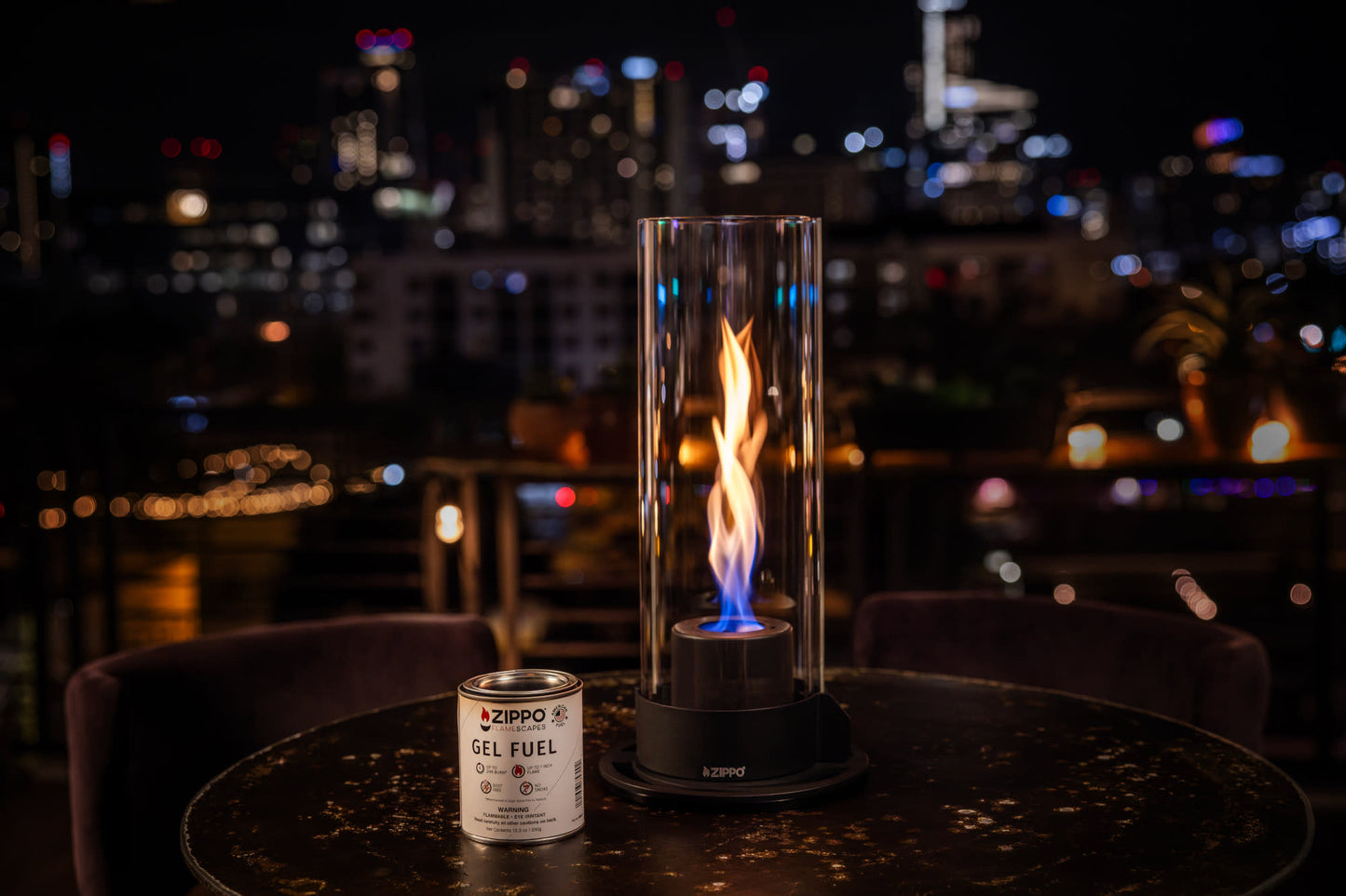 Lifestyle image of Zippo FlameScapesâ„¢ Spiral Fire Feature XL in black, lit on a table with the fuel canister