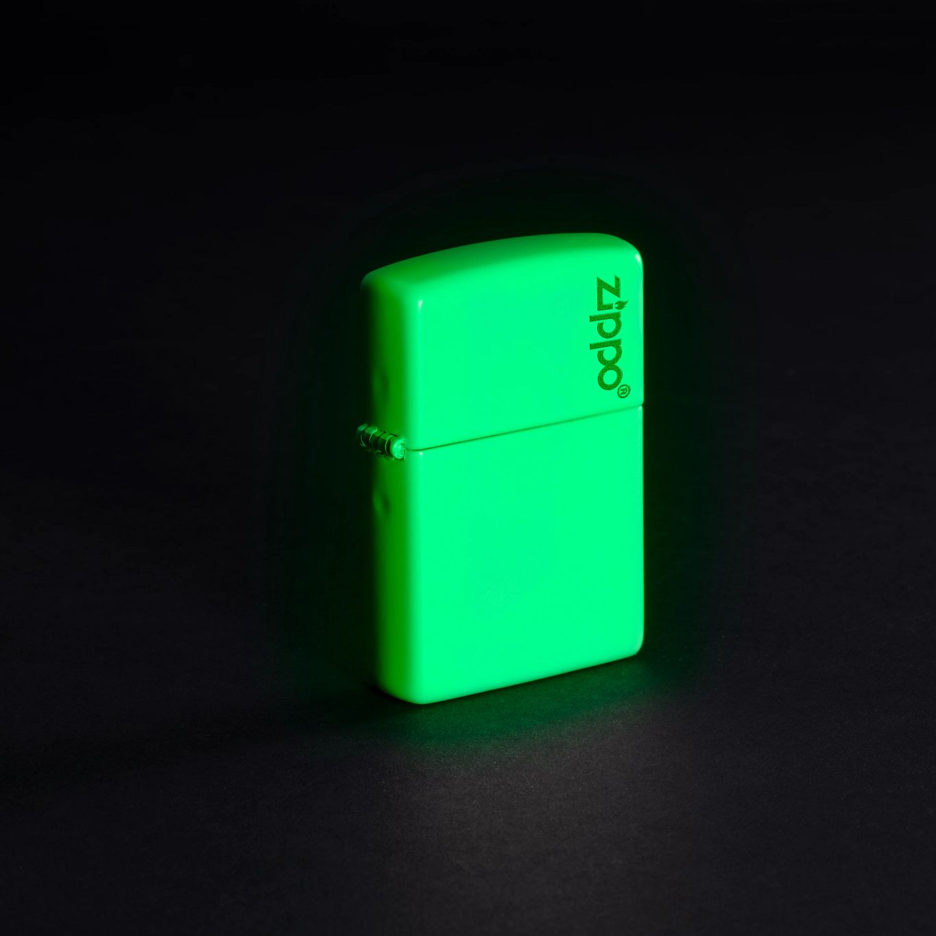 Lifestyle image of Classic Glow In The Dark Zippo Logo Windproof Lighter glowing in the dark.