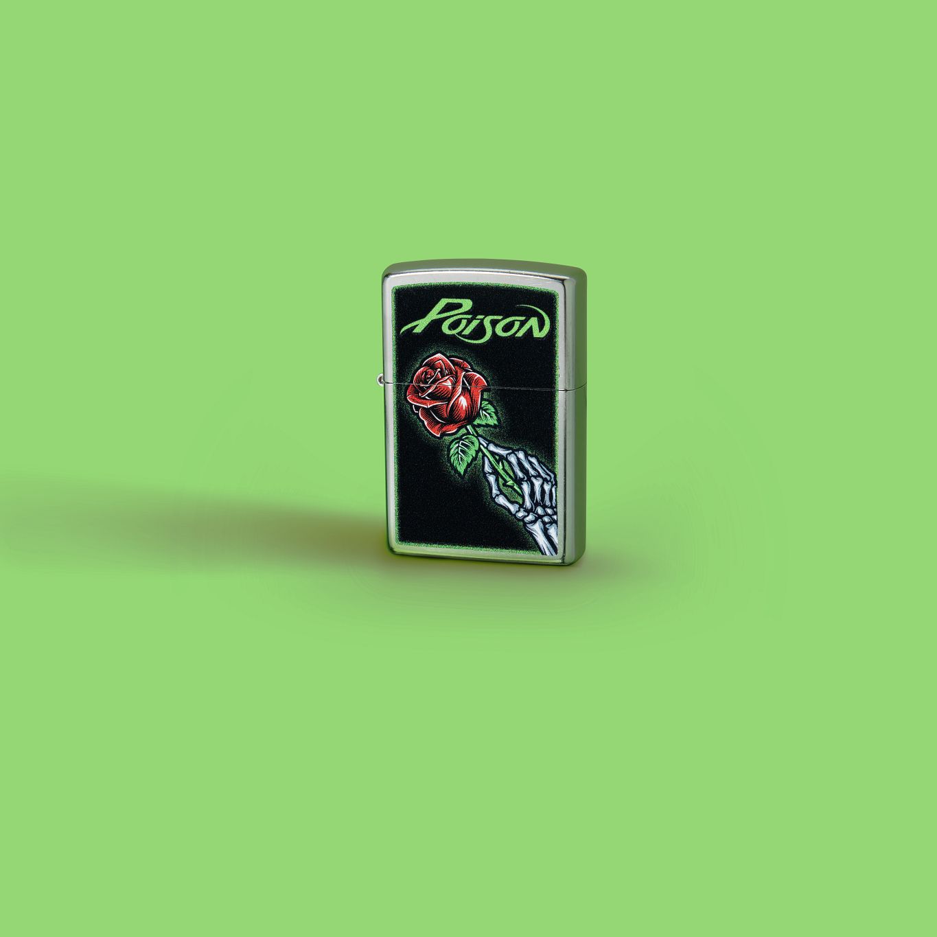 Lifestyle image of Zippo Poison Vibrant Rose Design Street Chrome Windproof Lighter standing against a bright green background.