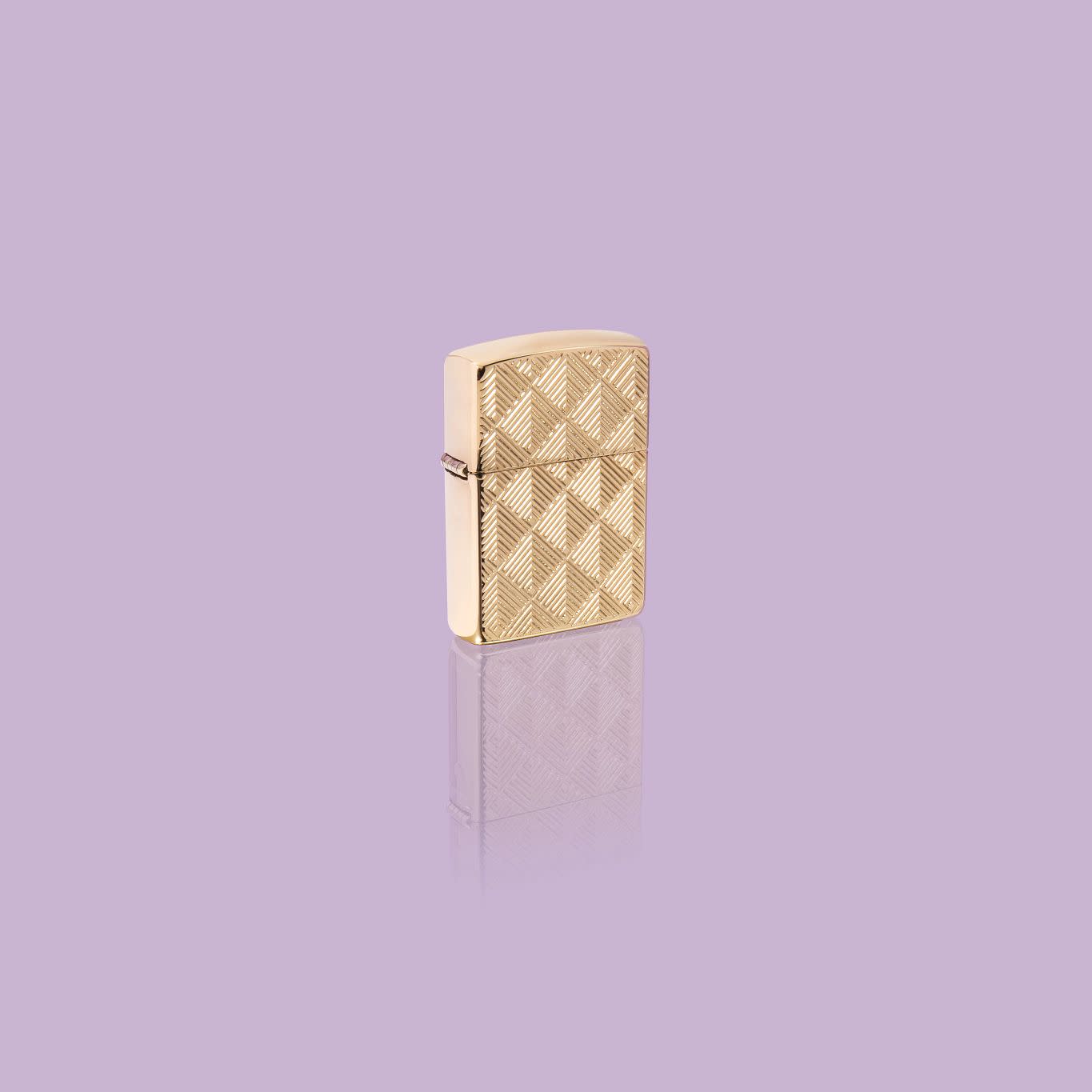 Glamour shot of Zippo Pattern Design Armor High Polish Brass Windproof Lighter standing in a purple scene.