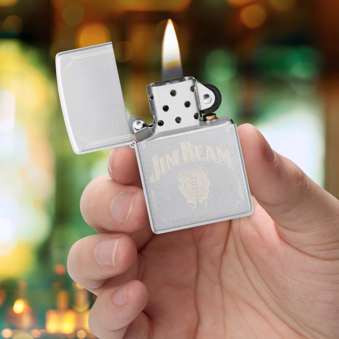 Zippo Jim Beam® Border Design Satin Chrome Windproof Lighter lit in hand.