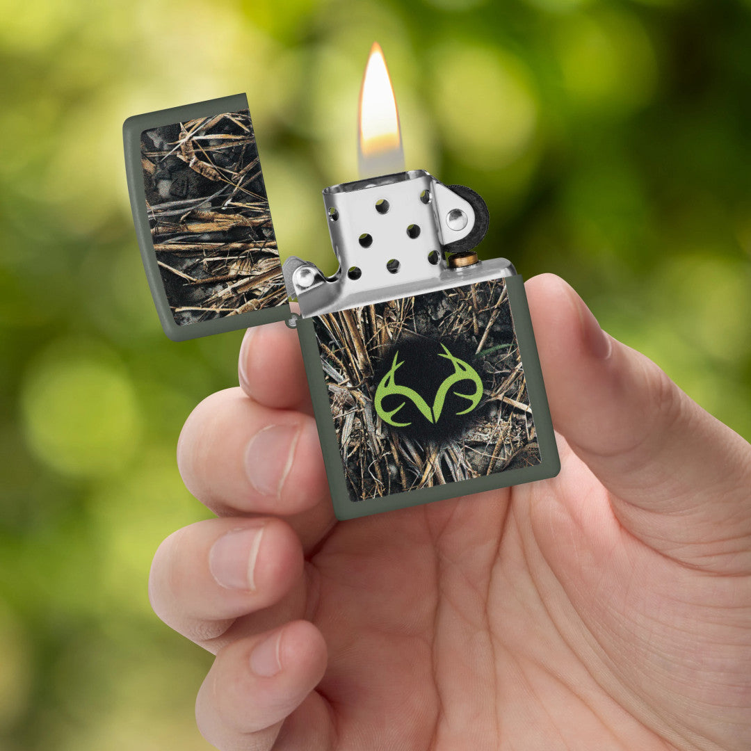 Zippo Realtree® Brush Design Green Matte Windproof Lighter lit in hand.