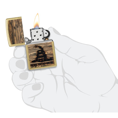 Zippo Don't Tread On Me® Woodburn Design Street Brass Windproof Lighter lit in hand.