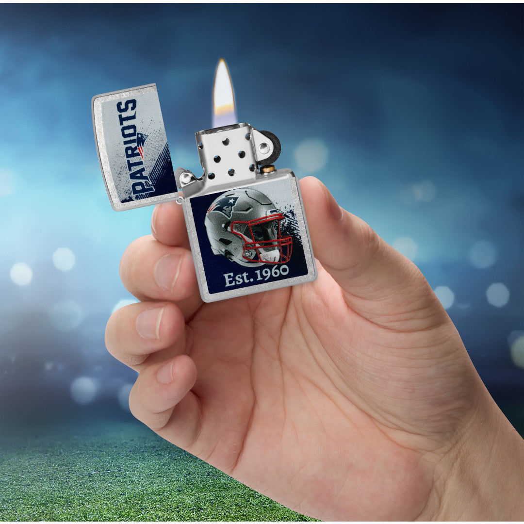 Zippo NFL New England Patriots Helmet Design Street Chrome Windproof Lighter lit in hand.