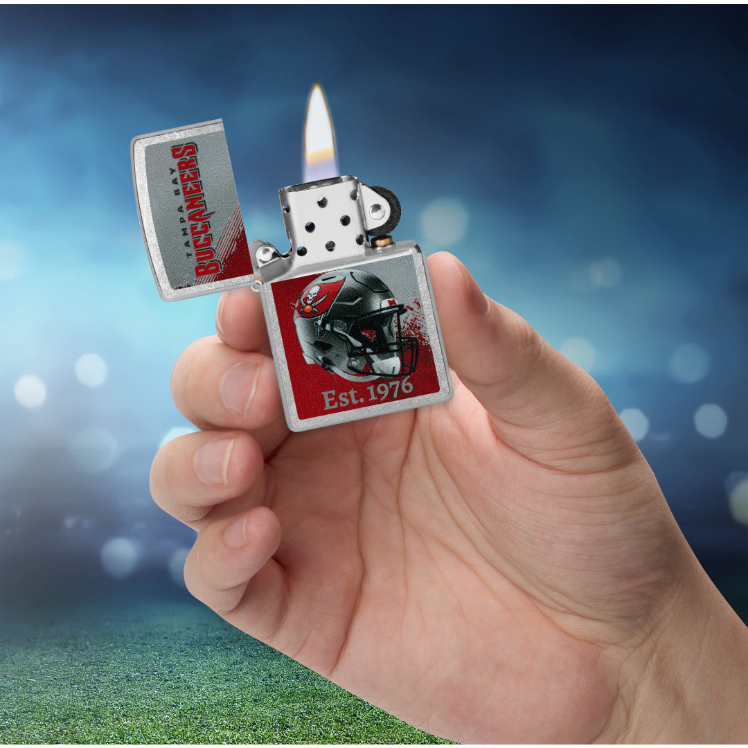 Zippo NFL Tampa Bay Buccaneers Helmet Design Street Chrome Windproof Lighter lit in hand.