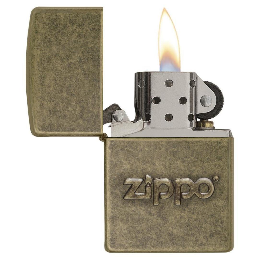 Zippo Stamp Antique Brass Lighter with its lid open and lit.
