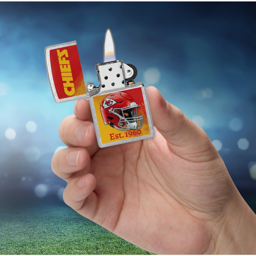 Zippo NFL Kansas City Chiefs Helmet Design Street Chrome Windproof Lighter lit in hand.