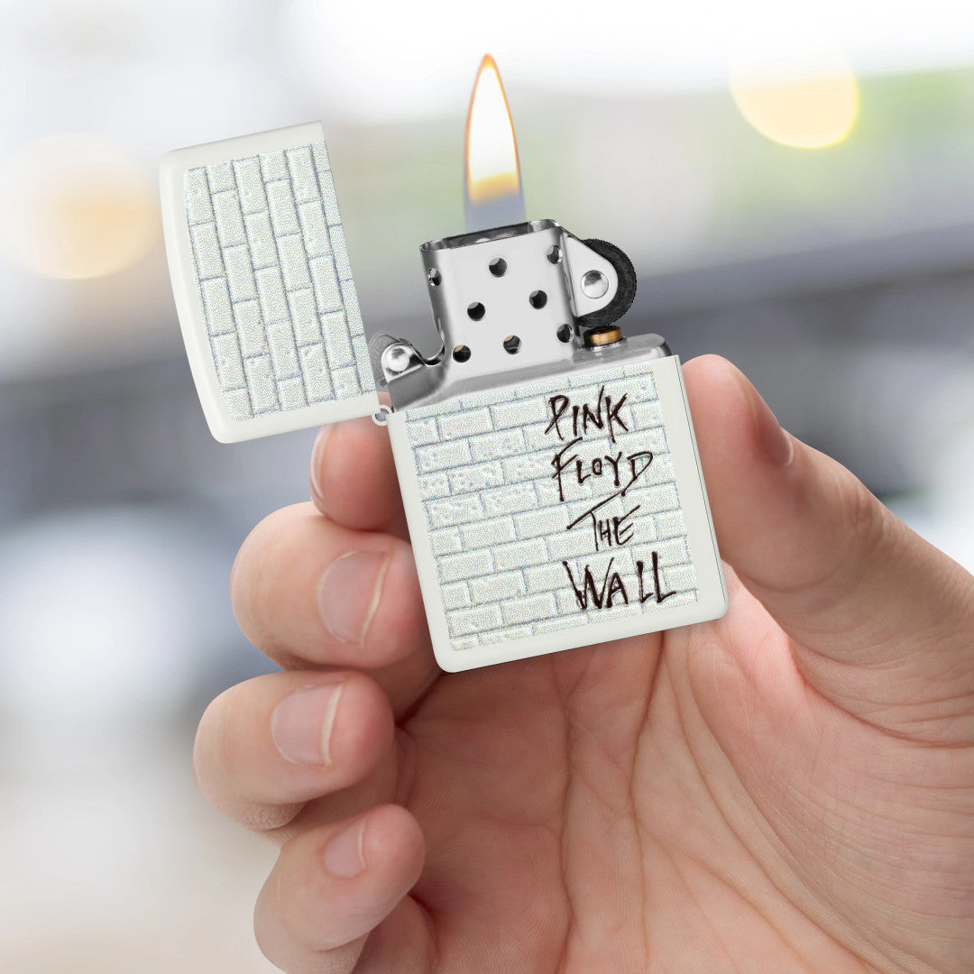 Zippo Pink Floyd The Wall Design White Matte Windproof Lighter lit in hand.