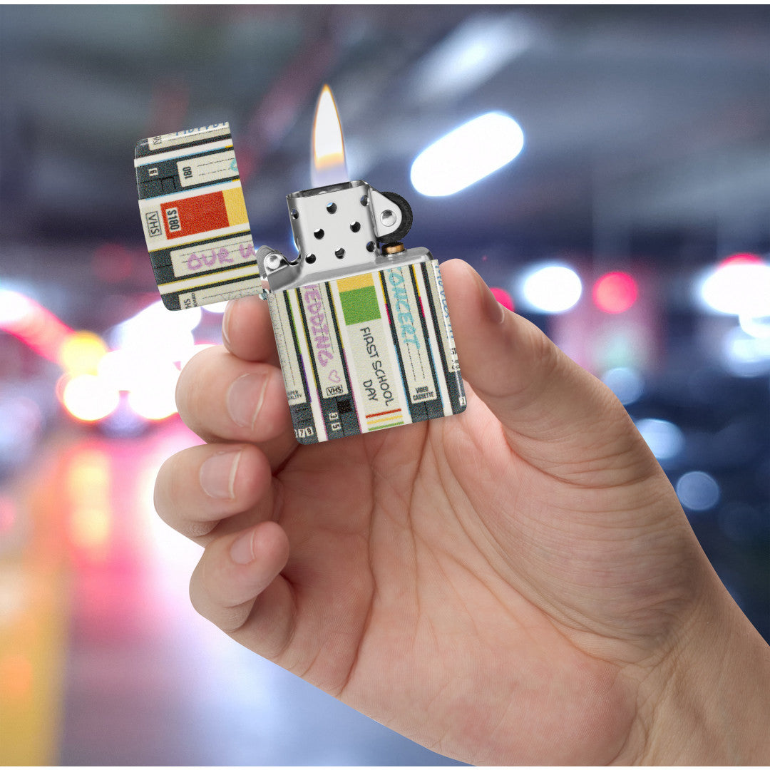 Zippo Home Video Design 540 Matte Windproof Lighter lit in hand.