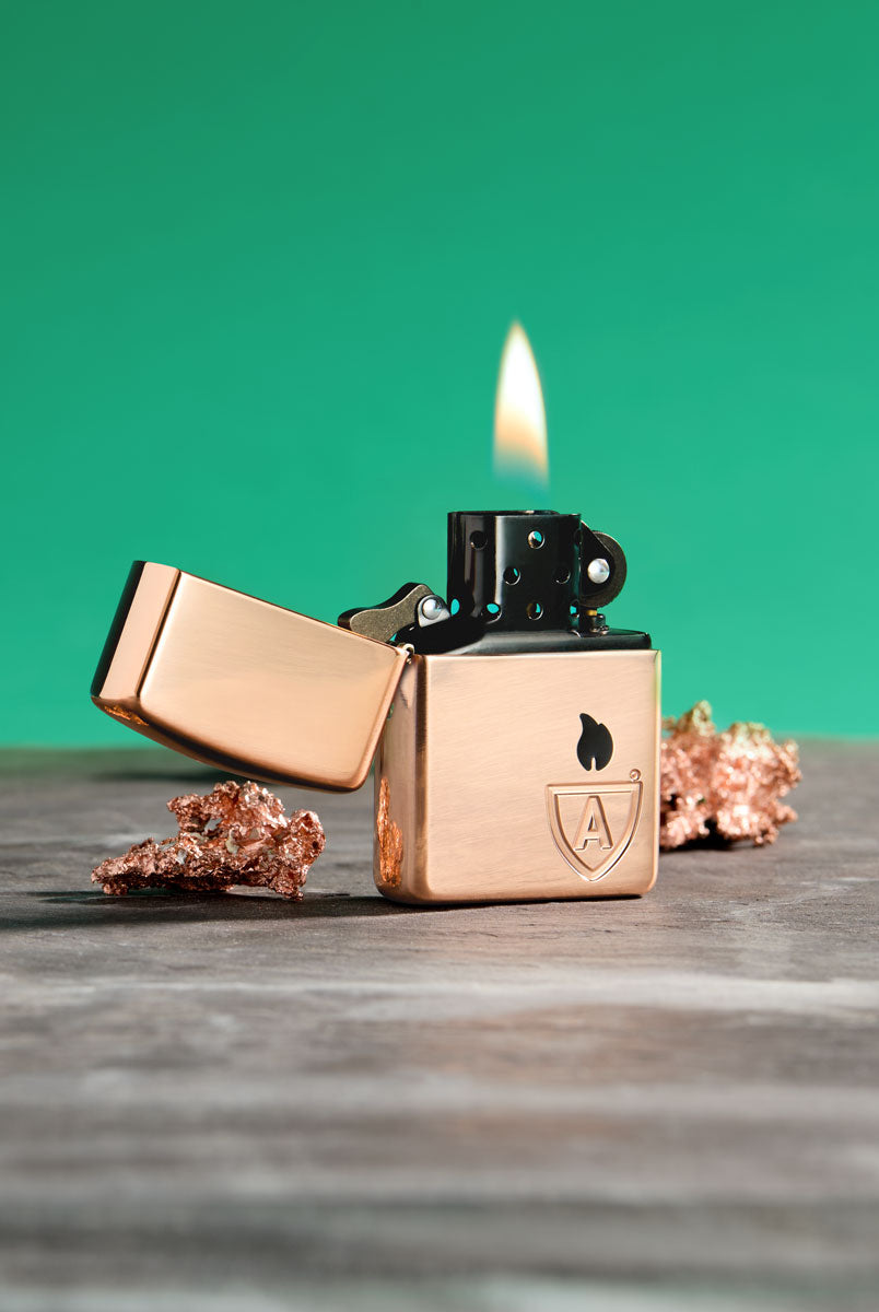 Classic Armor® Solid Copper lighter with black insert on green background.