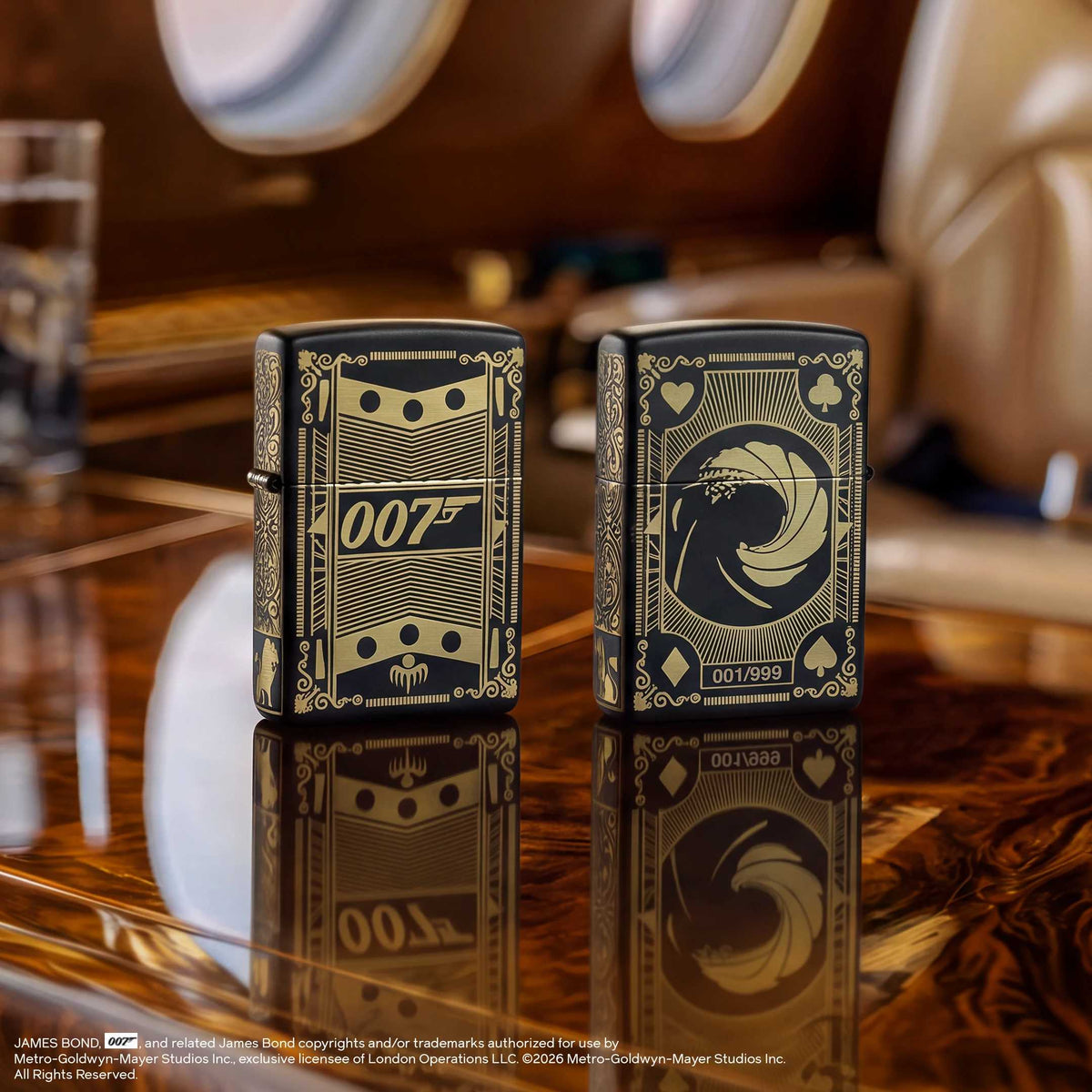 Two black and gold James Bond Zippo lighters on a polished wooden table in a luxury interior setting.