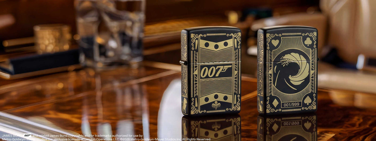 Two James Bond Zippo lighters on a reflective wooden surface. 