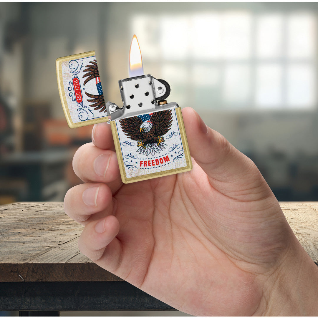 Zippo Soaring Freedom Design Street Brass Windproof Lighter lit in hand.