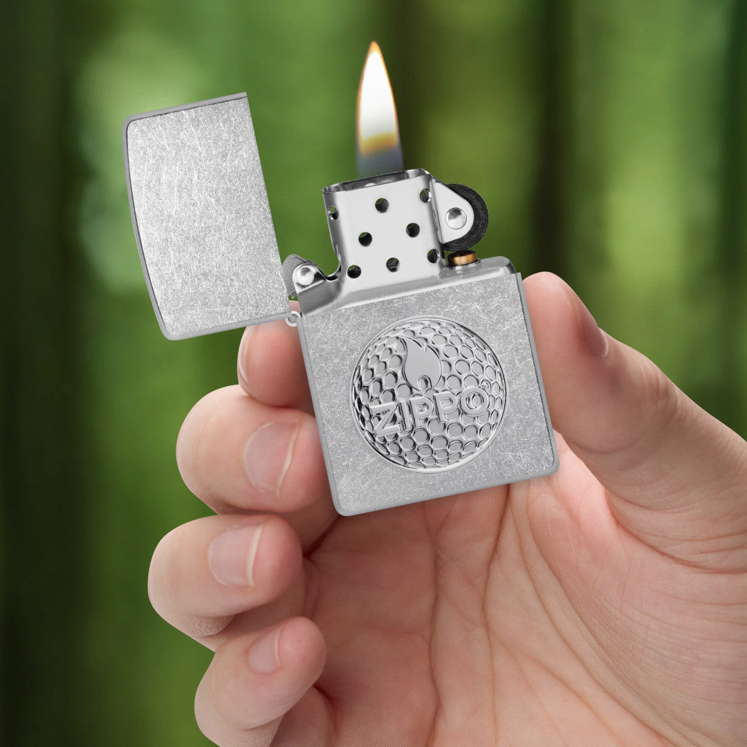 Zippo Golf Ball Marker Emblem – Zippo Design Street Chrome Windproof Lighter lit in hand.