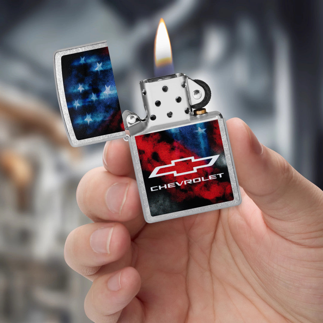 Zippo Chevrolet® Flag Design Street Chrome Windproof Lighter lit in hand.