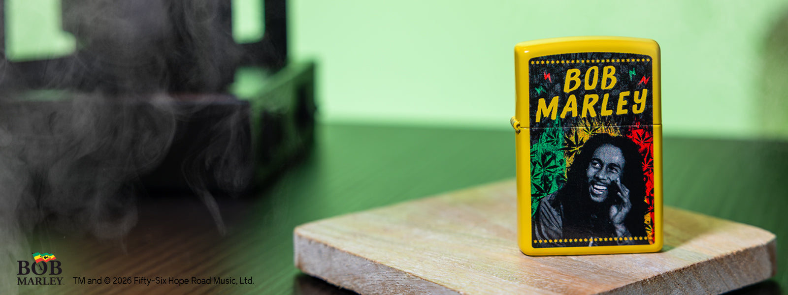 Bob Marley Zippo lighter on a wooden block with a green background
