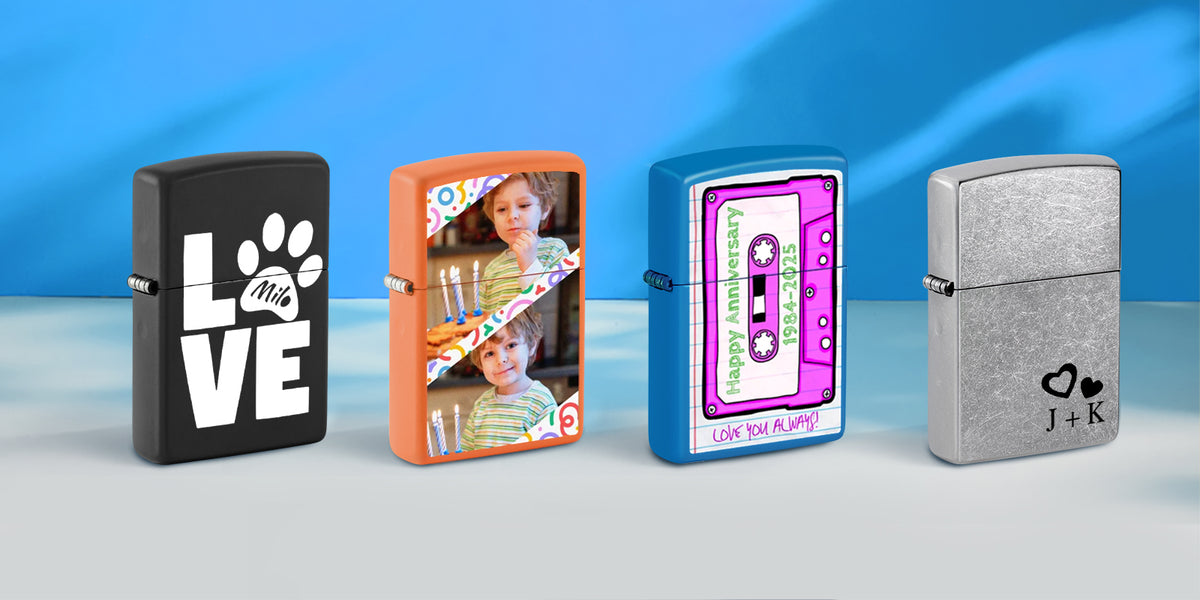 Four customized lighter designs lined up on a light gray surface against a blue gradient background. The lighter designs include: a matte black one with 'LOVE this paw print' in white, an orange one with a child's photo and 'Happy Anniversary' text, a metallic blue one with a pink cassette tape graphic, and a brushed silver one with a heart logo and 'J+K' monogram.