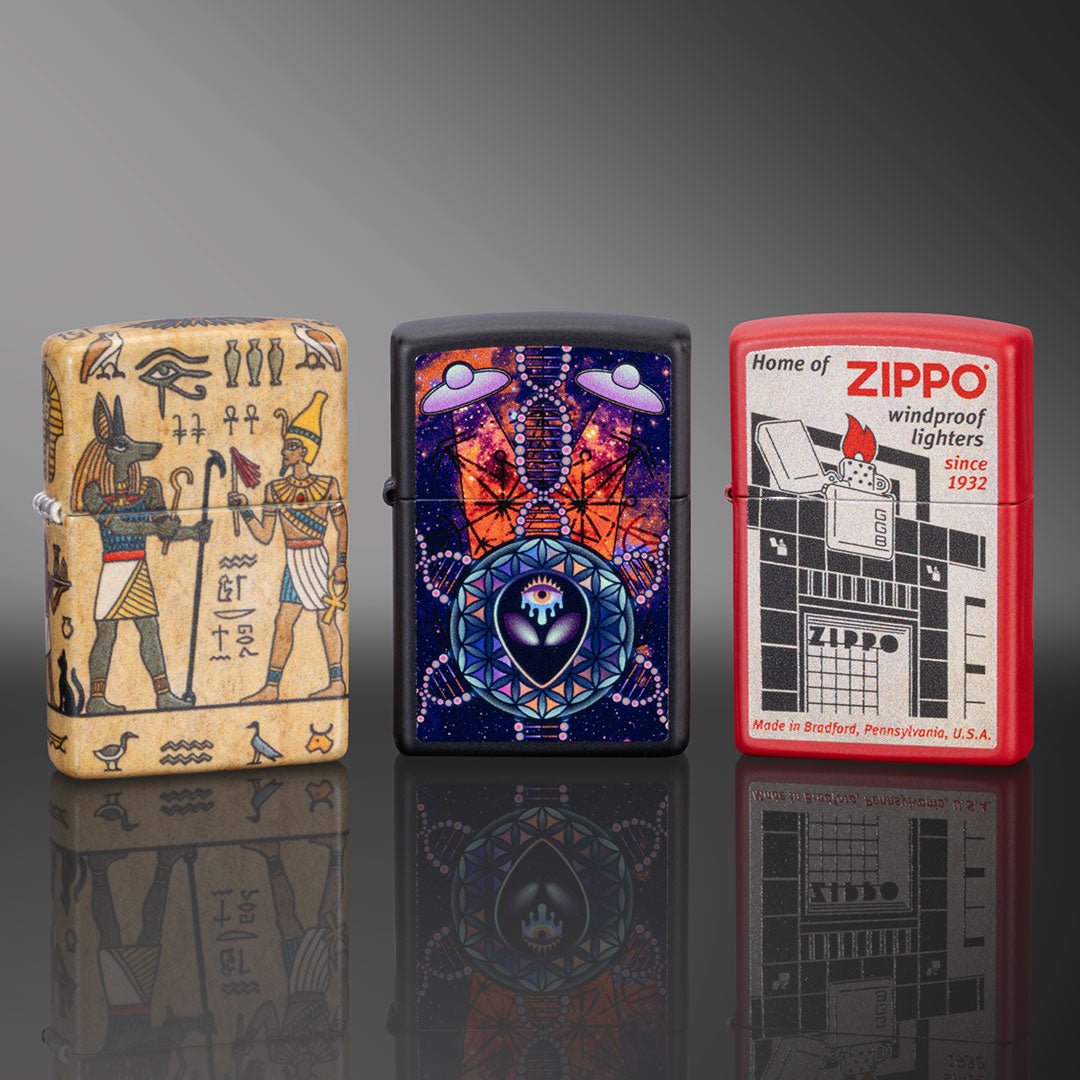 Three Zippo lighters with different designs on a reflective surface.