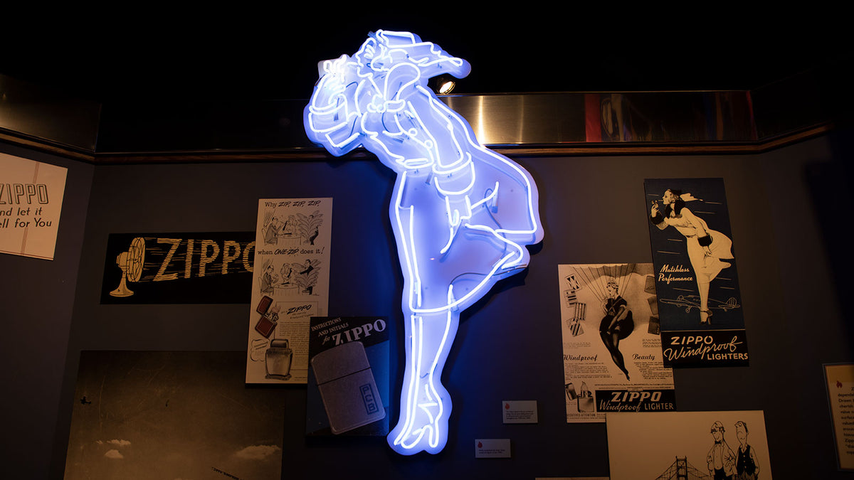 A glowing blue neon sign depicting Windy, mounted on a dark wall with vintage Zippo posters and signs in the background.