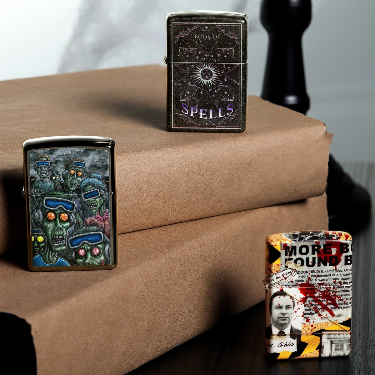 Three Zippo Web Debut lighters on a stack of books.