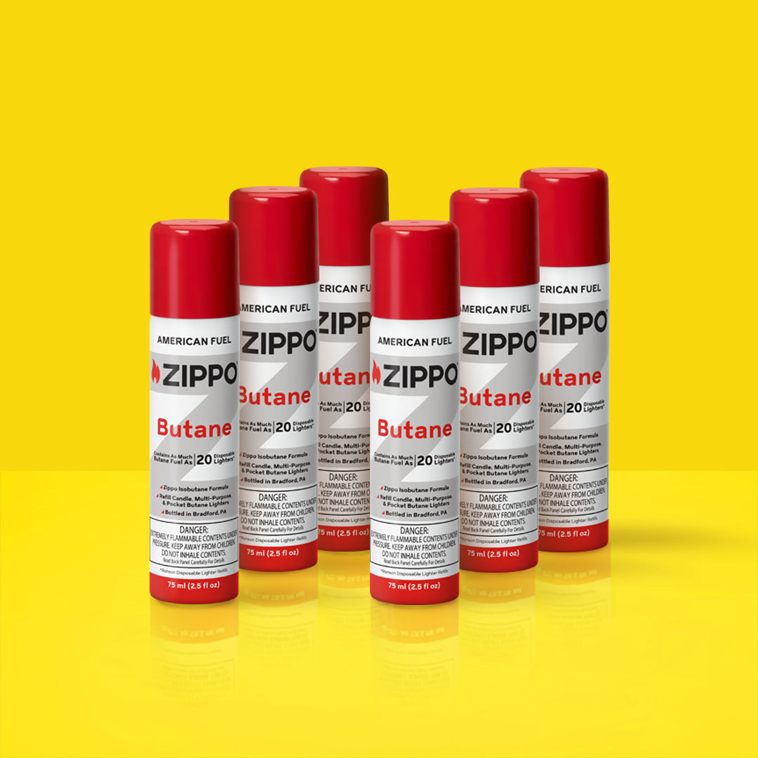 Six Zippo 75ml butane cans on a yellow background