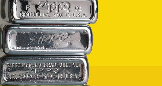 Three Zippo lighters stacked on top of each other behind a yellow background