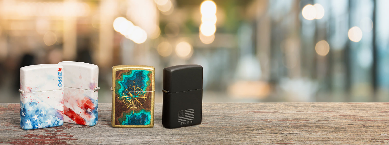 Four Zippo lighters on a wooden surface with a blurred background
