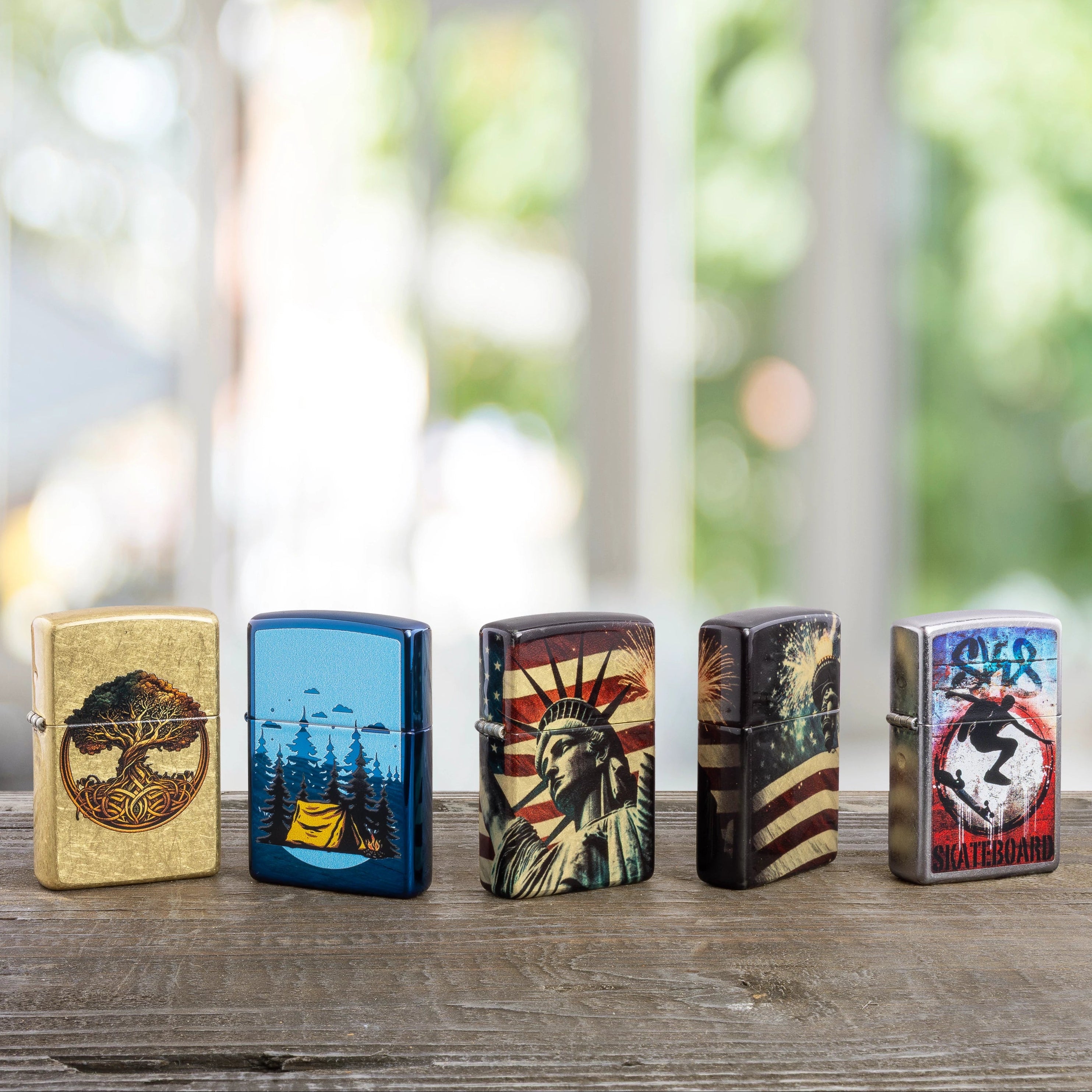 Five Zippo lighters on a wood surface with trees in the background. 