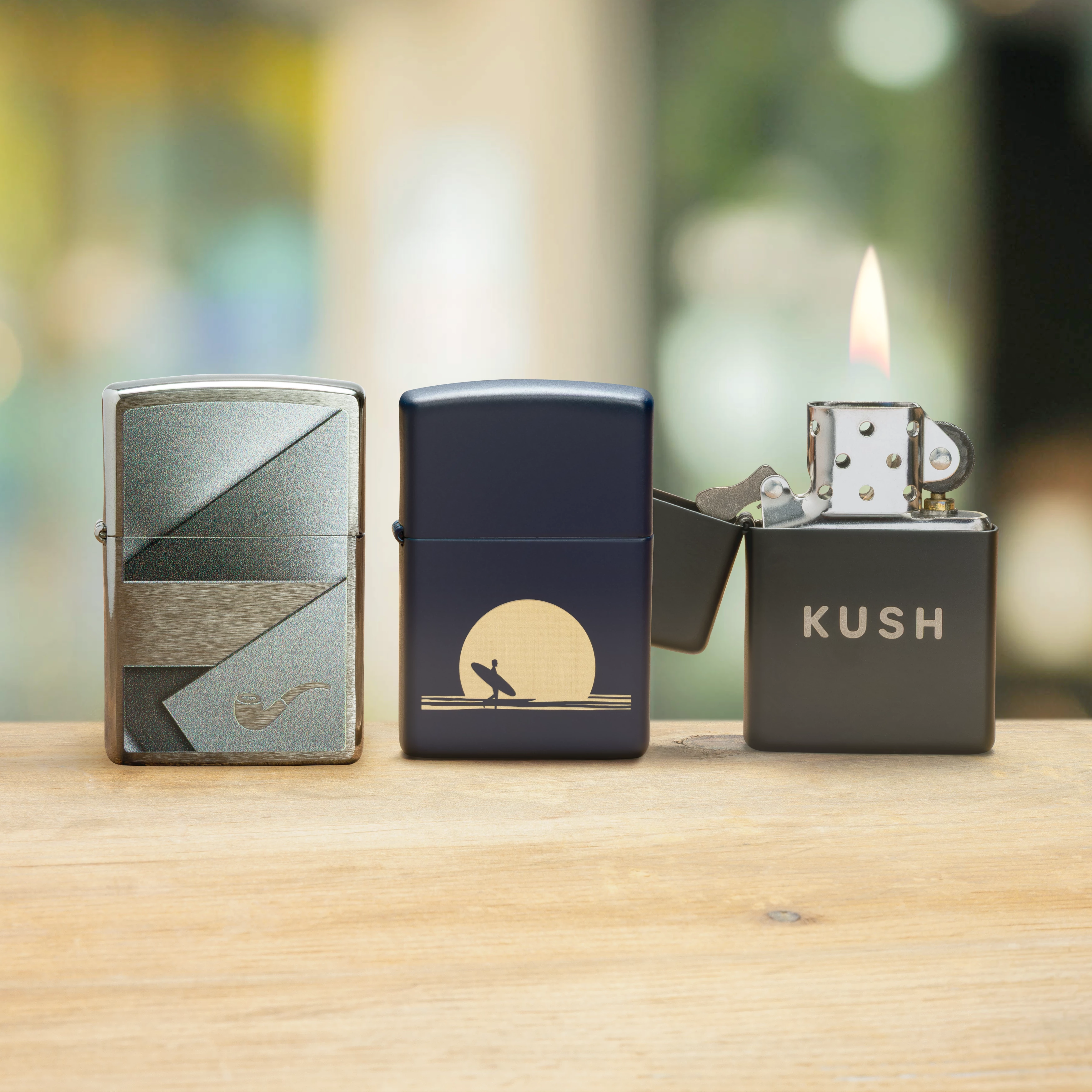 Three Spring Supplement Zippo lighters on a wooden surface with a blurred background