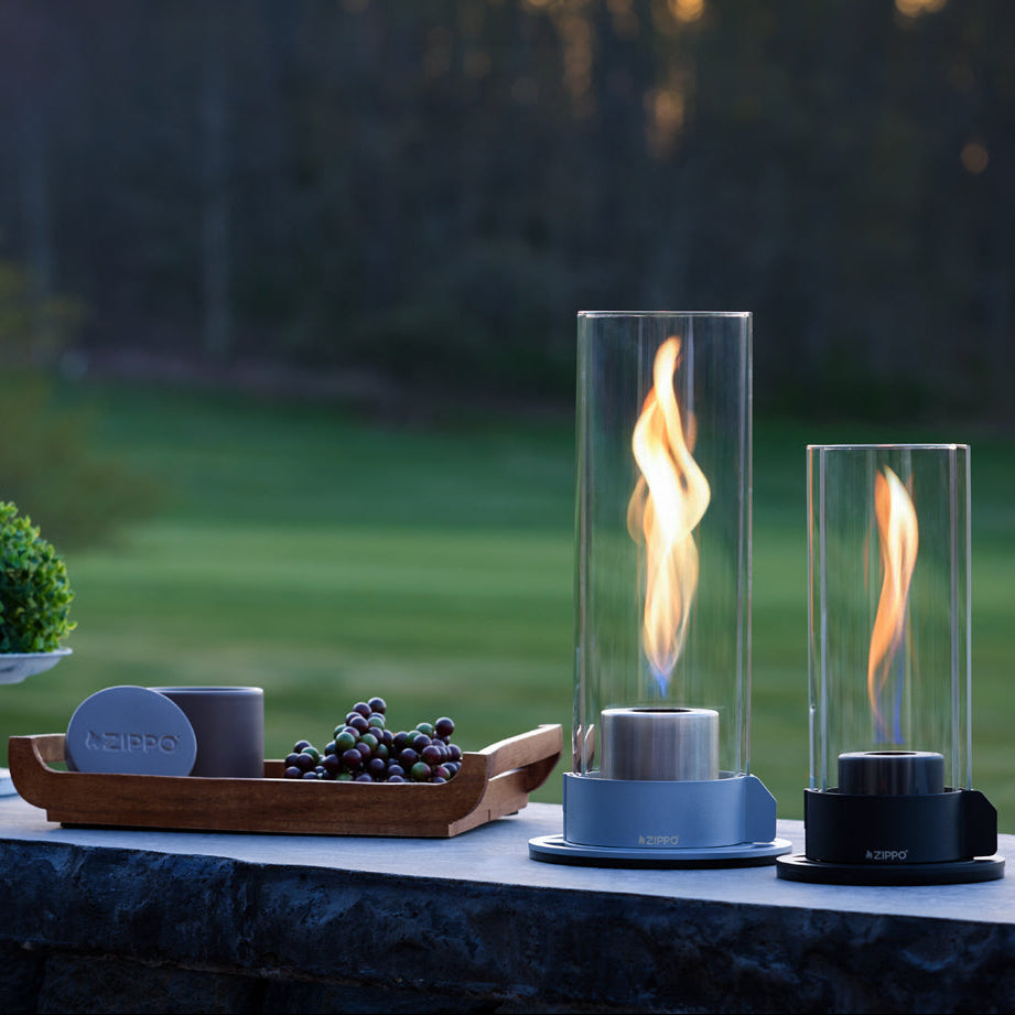 Two Zippo FlameScapes® and a Citronella candle on a patio with trees in the background.