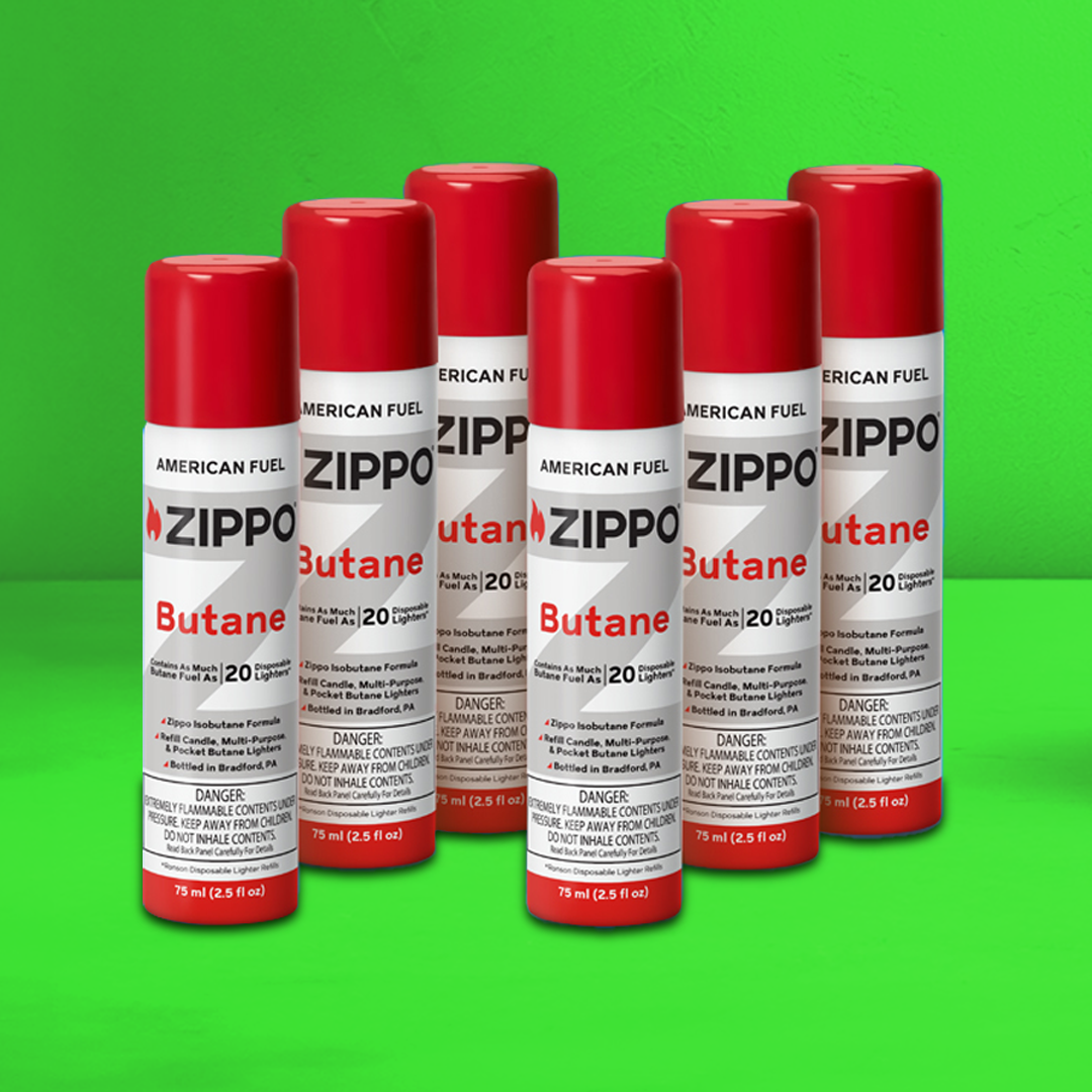 Multiple Zippo Butane cans on a green background