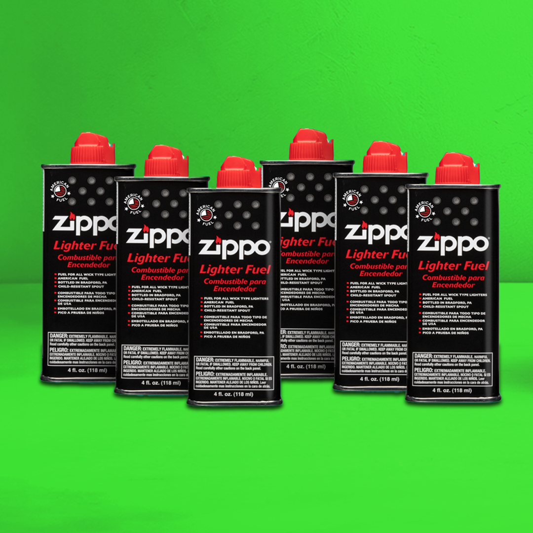 Multiple Zippo lighter fuel cans on a green background.