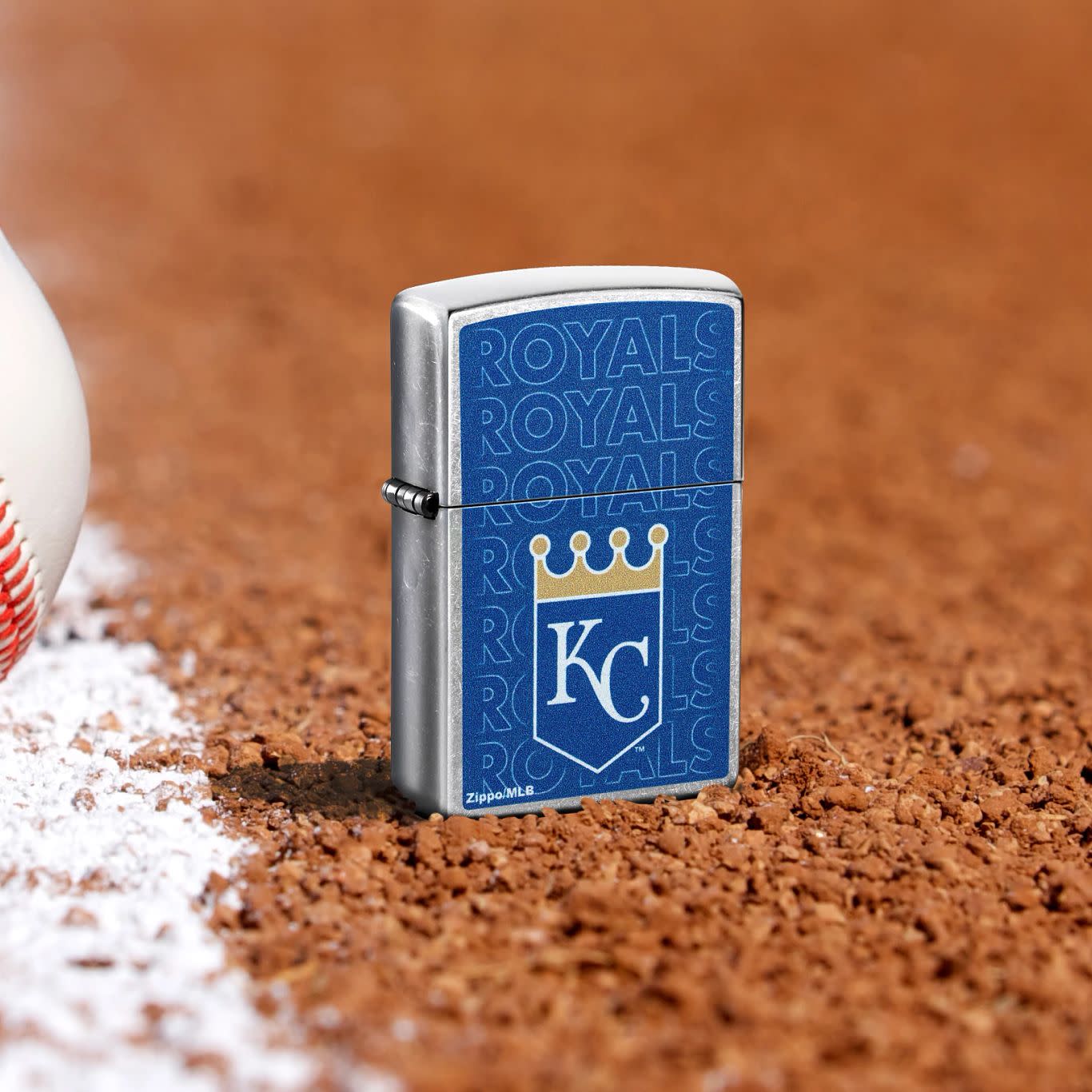 Lifestyle image of Zippo MLB® Kansas City Royals Street Chrome Windproof Lighter standing in the dirt on a baseball field.