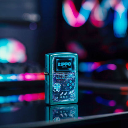 Lifestyle image of Zippo Game On Design Candy Teal Windproof Lighter standing on a dark surface showing the front and hinge side of the lighter with a neon gaming vibe background. 

