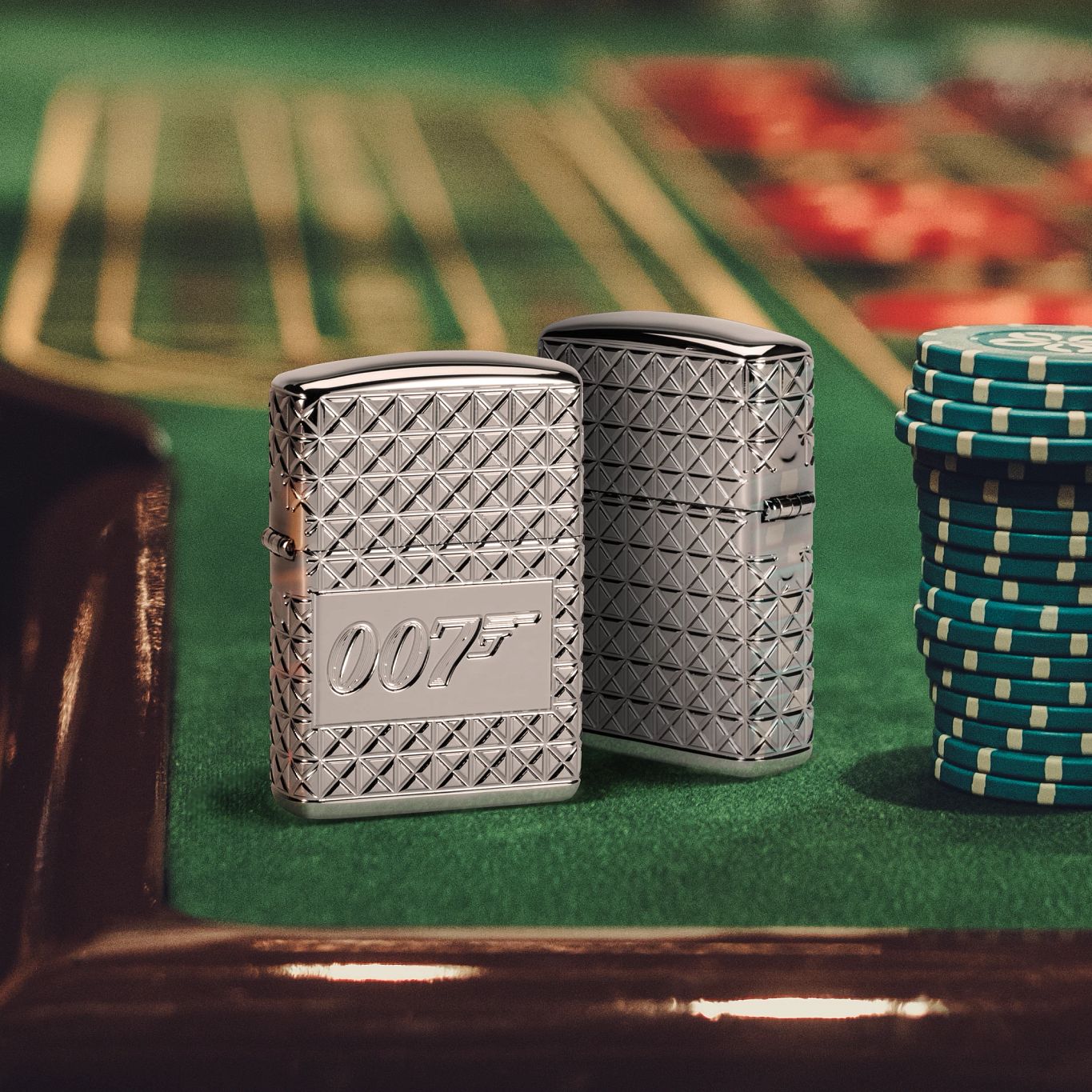 Lifestyle image of two Zippo James Bond Pattern High Polish Chrome Armor® Windproof Lighters; one showing the front of the lighter and the other showing the back and hinge side of the lighter, both standing on a poker table with chips stacked next to them.