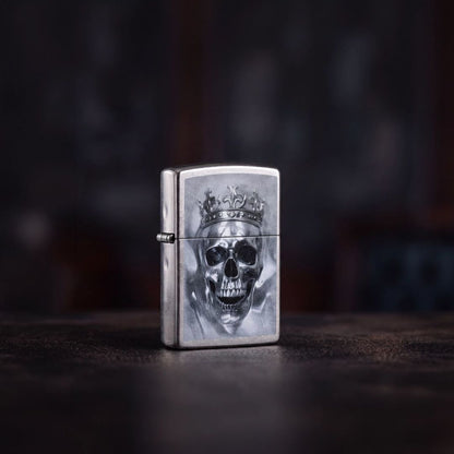 Lifestyle image of Zippo King Cranium Design Street Chrome Windproof Lighter standing on a dark surface showing the front and hinge side of the lighter with a dark background. 

