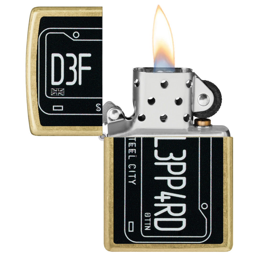 Zippo Def Leppard Steel City Design Street Brass Windproof Lighter with its lid open and lit.