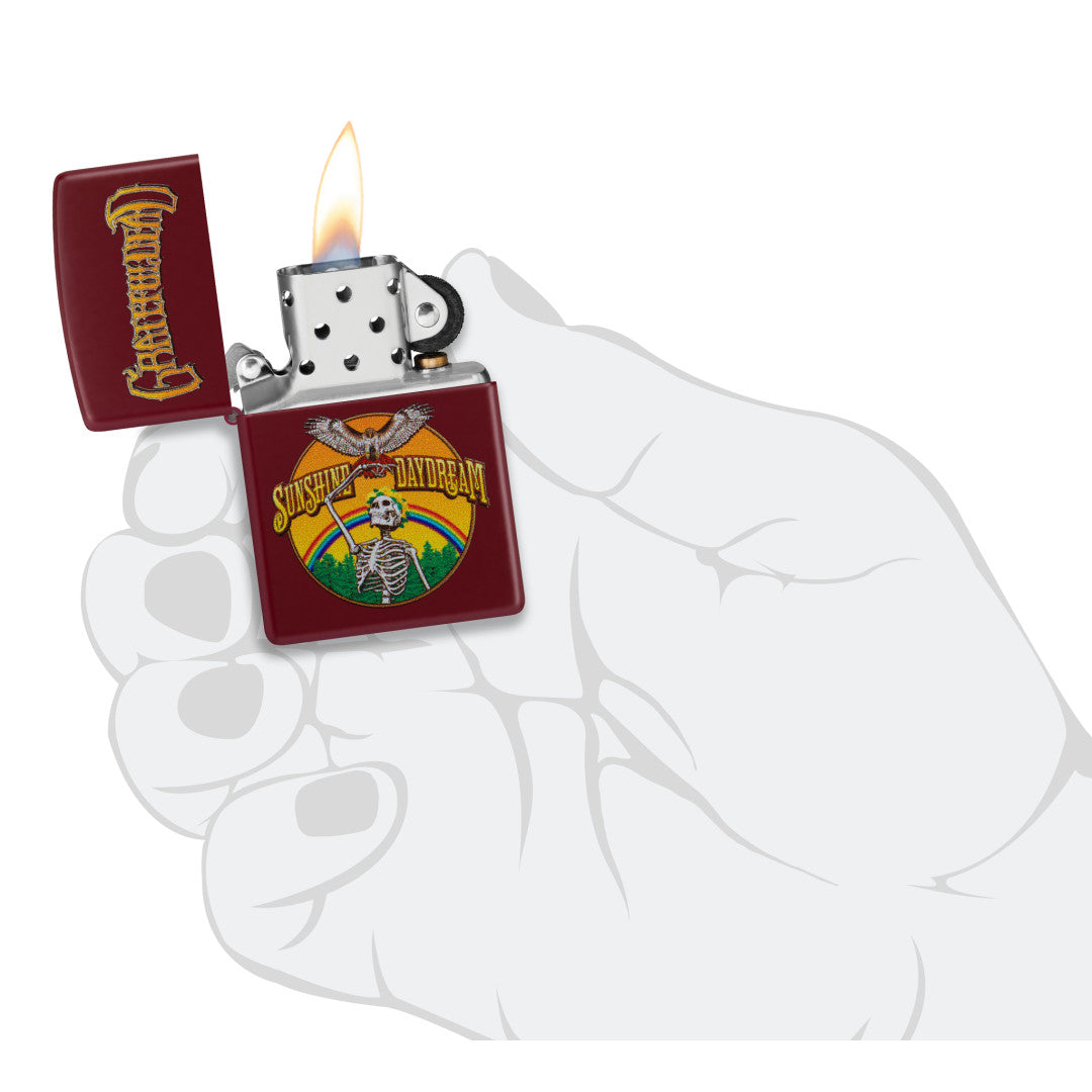 Zippo Grateful Dead Sunshine Daydream Design Merlot Windproof Lighter lit in hand.