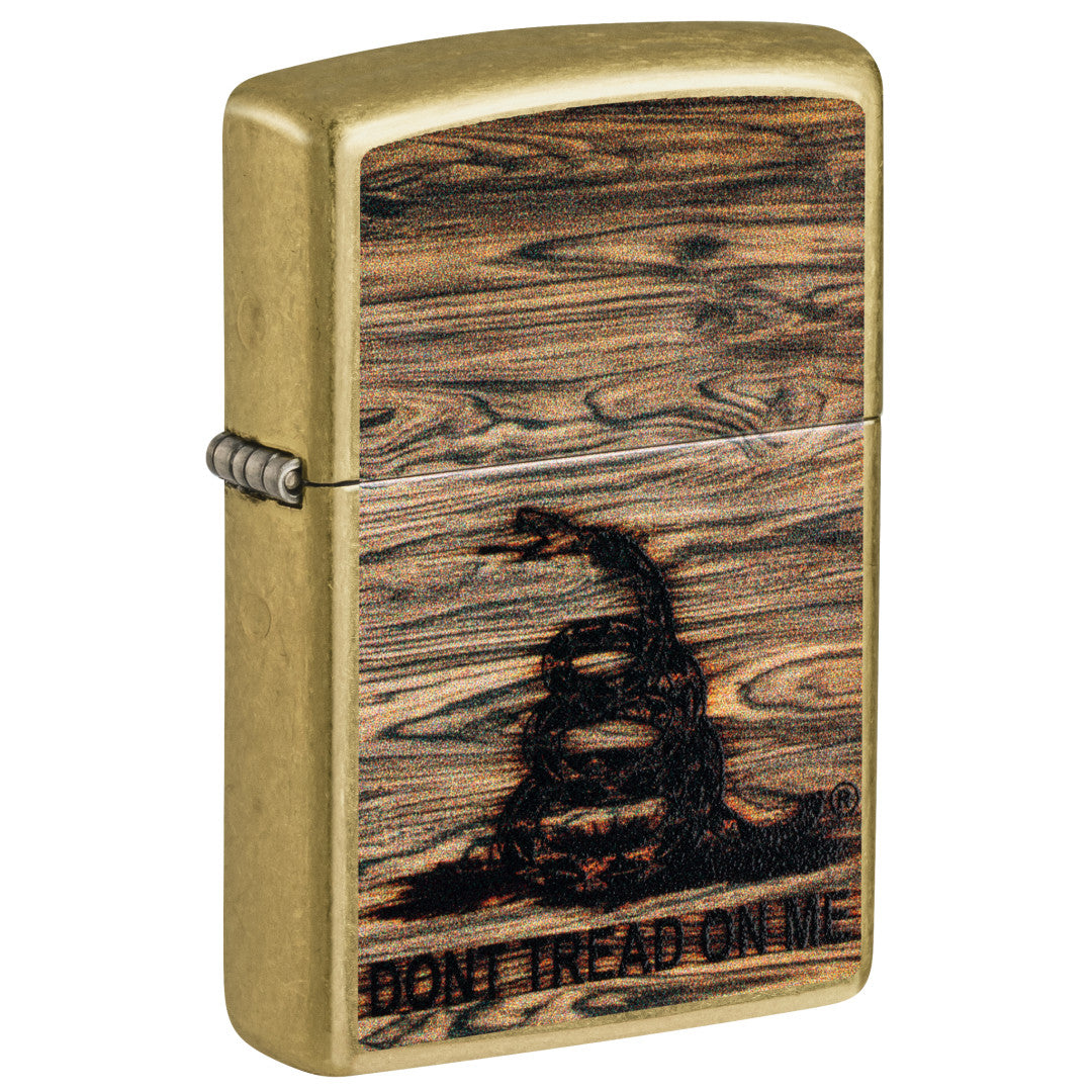 Front shot of Zippo Don't Tread On Me® Woodburn Design Street Brass Windproof Lighter standing at a 3/4 angle.