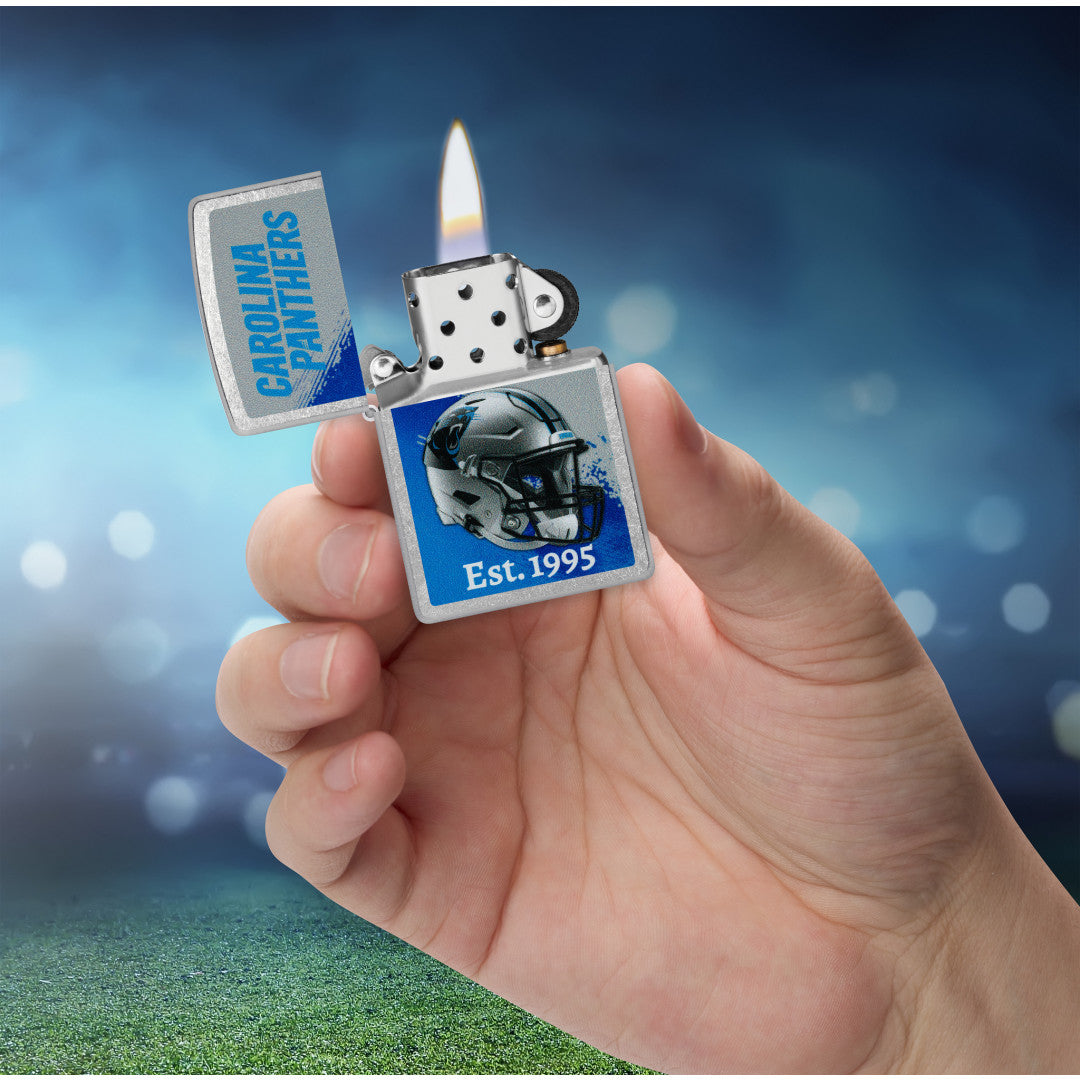 Zippo NFL Carolina Panthers Helmet Design Street Chrome Windproof Lighter lit in hand.