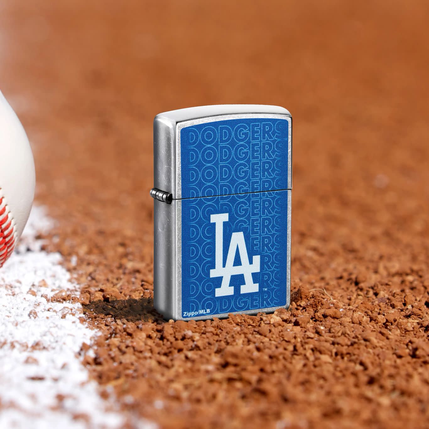 Lifestyle image of Zippo MLB® Los Angeles Dodgers Street Chrome Windproof Lighter standing in the dirt on a baseball field.