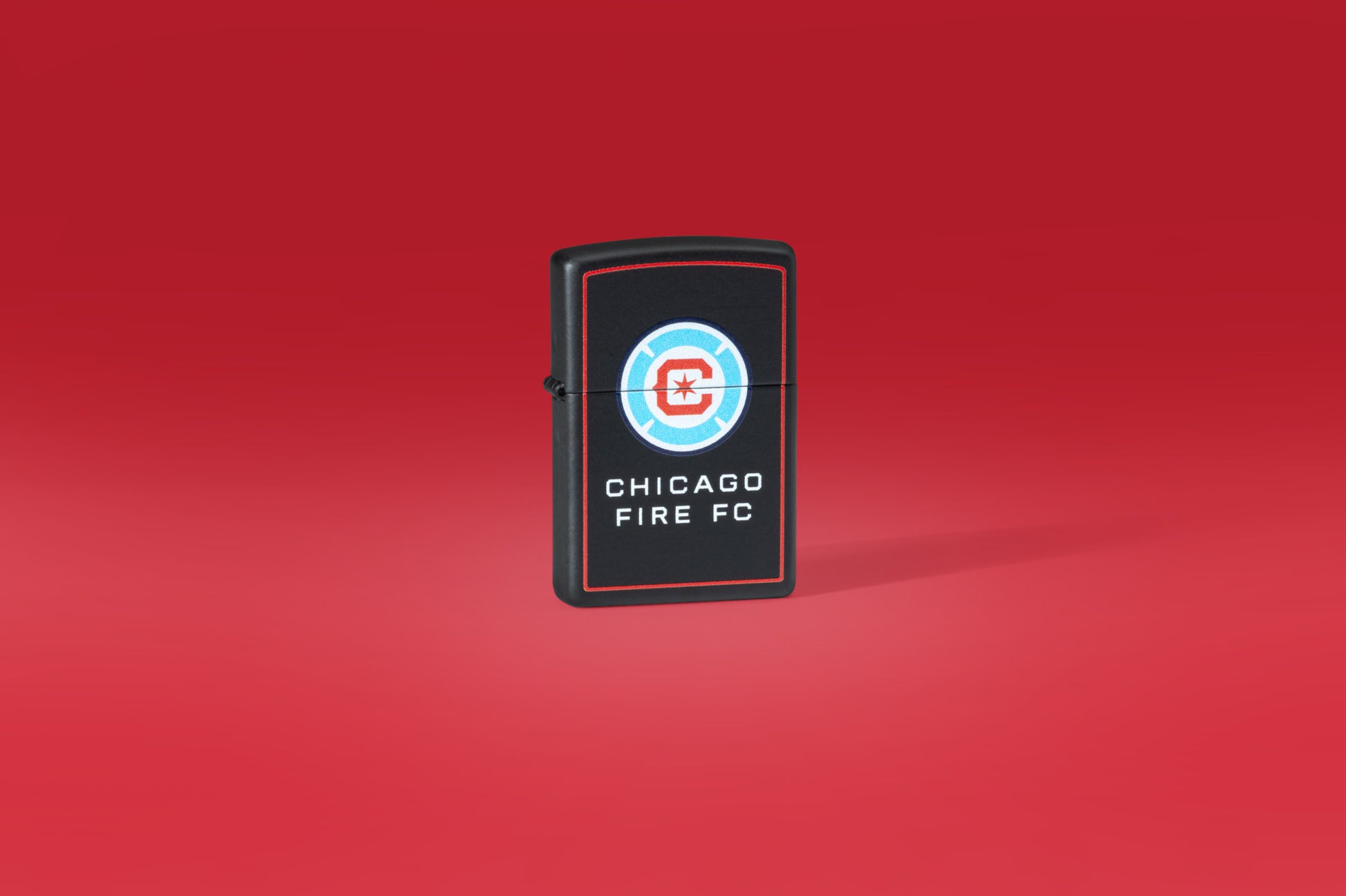 Lifestyle image on Red Background of Chicago Fire FC Windproof Lighter