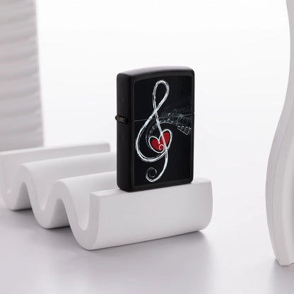 Lifestyle image of Zippo Love Clef Design Black Matte Windproof Lighter standing on a white wavy decorative object next to other white decorative object with a white background. 

