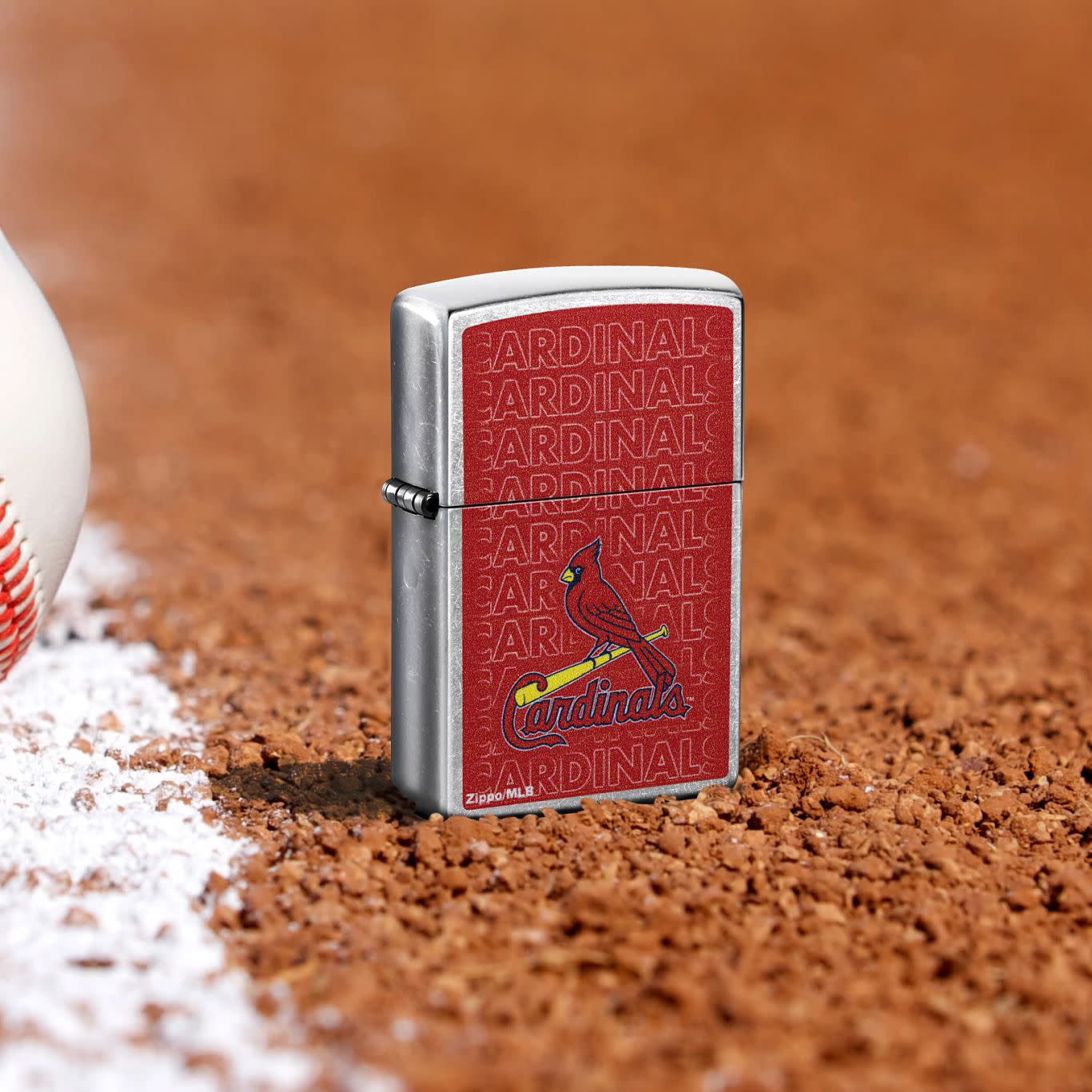 Lifestyle image of Zippo MLB® St. Louis Cardinals Street Chrome Windproof Lighter standing in the dirt on a baseball field.